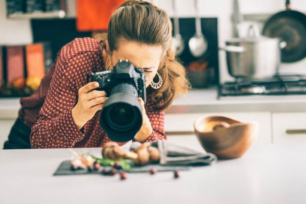Contribuez et partagez 2 Young modern woman photographing food in kitchen